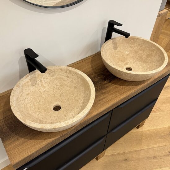 Vasques en travertin de forme ronde posés sur un meuble