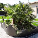 Réalisation dans un jardin d'un massif de plantes avec les piquets ardoise non oxydé
